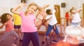 Smiling little girl training vigorous dance in children dance studio