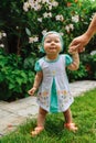 Smiling little girl in in a turquoise kerchief standing and holding her father hand. Little girl`s portrait Royalty Free Stock Photo