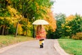 Smiling little girl with umbrella in raincoat and boots outdoor Royalty Free Stock Photo