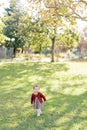 Smiling little girl walking on green grass in the park Royalty Free Stock Photo