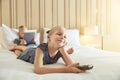 Smiling little girl watching television on a bed Royalty Free Stock Photo