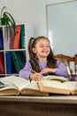 smiling little girl is watching a video lesson on the computer. Royalty Free Stock Photo