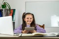 smiling little girl is watching a video lesson on the computer. Royalty Free Stock Photo