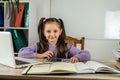 smiling little girl is watching a video lesson on the computer. Royalty Free Stock Photo