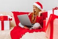 Smiling little girl wearing Santa Claus hat meets Christmas New Year via a video call on a laptop with friends  Quarantine  Self- Royalty Free Stock Photo