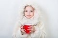 Smiling little girl in winter clothes with a red cup of hot drink. Royalty Free Stock Photo
