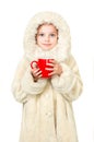 Smiling little girl in winter clothes with a red cup of hot drink Royalty Free Stock Photo