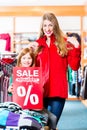 Smiling little girl and woman promoting sale offer