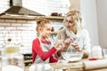 Smiling little kid in red dress asking about baking process