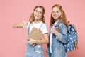 Smiling little kids girls 12-13 years old in white t-shirt, denim clothes with backpack isolated on pink background Royalty Free Stock Photo
