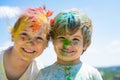 Smiling little kids portrait. Painted faces of funny kids. Children holi festival of colors. Little boy and girl plays