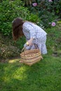 Smiling little latina girl in garden in Spring dress with Basket