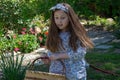 Smiling little latina girl in garden in Spring dress with Basket