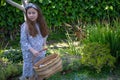 Smiling little latina girl in garden in Spring dress with Basket