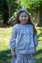 Smiling little latina girl in garden in Spring dress