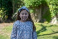 Smiling little latina girl in garden in Spring dress