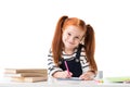 smiling little redhead schoolgirl drawing in notebook with felt tip pens and looking at camera Royalty Free Stock Photo