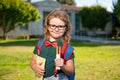 Smiling little school student with backpack book. Portrait of happy schoolboy pupil outdoor. Royalty Free Stock Photo