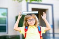 Smiling little student boy wearing school backpack and holding exercise book. Portrait of happy pupil outside the Royalty Free Stock Photo