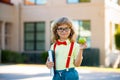 Smiling little student boy wearing school backpack and holding exercise book. Portrait of happy pupil outside the Royalty Free Stock Photo