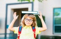 Smiling little student boy wearing school backpack and holding exercise book. Portrait of happy pupil outside the Royalty Free Stock Photo