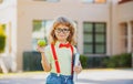 Smiling little student boy wearing school backpack and holding exercise book. Portrait of happy pupil outside the Royalty Free Stock Photo