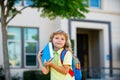 Smiling little student boy wearing school backpack and holding exercise book. Portrait of happy pupil outside the Royalty Free Stock Photo