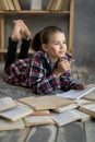 smiling little student girl with book lying on the floor, education and school Royalty Free Stock Photo