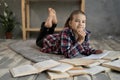 smiling little student girl with book lying on the floor, schoolgirl with books looking at camera and smiling, education Royalty Free Stock Photo