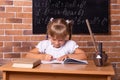 Smiling little student girl sitting at a school desk and studying math. The child is doing homework. Preschool education, self Royalty Free Stock Photo