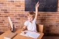 Smiling little student girl sitting at a school desk and studying math. Child pulls his hand up. Preschool education Royalty Free Stock Photo