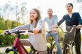 Smiling long-haired little girl with father and mother during outdoor bicycle riding. They enjoy togetherness, happy parenthood Royalty Free Stock Photo