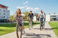 Smiling long-haired little girl with father and mother during summer city outdoor bicycle riding. They enjoy togetherness, happy Royalty Free Stock Photo