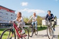 Smiling long-haired little girl with father and mother during summer city outdoor bicycle riding. They enjoy togetherness, happy Royalty Free Stock Photo