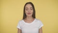 Smiling long-haired woman middle age on yellow background in studio. Middleweight woman in basic white t-shirt