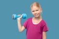 Smiling longhaired girl with dumbbell in hand