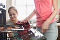 Smiling looking at mother removing cookie tray from oven at home