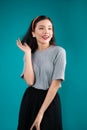 Smiling lovely asian woman dressed in pin-up style dress over bl Royalty Free Stock Photo