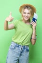 Smiling Lovely Dreaming Winsome Llovely Smiling Young Girl in Straw Hat Holding Passport with Tickets And Showing thumbs Up Over