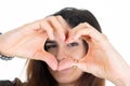 Smiling lovely girl making heart shape front face eye with her fingers hand isolated on white background Royalty Free Stock Photo