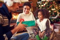 Smiling lovely girl receiving Christmas present from parents Royalty Free Stock Photo