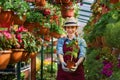 Smiling lovely young woman florist arranging plants in flower shop. The hobby has grown into a small business. Royalty Free Stock Photo