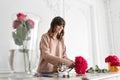 Smiling lovely young woman florist arranging plants in flower shop. People, business, sale and floristry concept Royalty Free Stock Photo