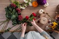 Smiling lovely young woman florist arranging plants in flower shop Royalty Free Stock Photo