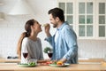 Smiling loving husband feeding wife, enjoying tender moment