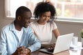 Smiling loving married mixed race couple surfing information online, shopping. Royalty Free Stock Photo