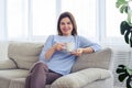 Smiling madam having rest on sofa with cup of coffee Royalty Free Stock Photo