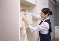 Smiling maid with White bathrobe with hanger in wardrobe, The concept of the hotel business Royalty Free Stock Photo