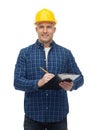 Smiling male builder in helmet with clipboard