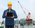 Smiling male builder in helmet with tablet pc